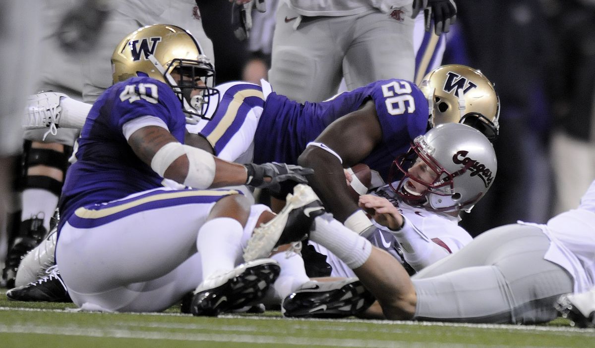 WSU quarterback Marshall Lobbestael lands on his back with Huskies on top during first half action at Husky Stadium in Seattle Saturday November 28, 2009 during the Apple Cup. (Christopher Anderson / The Spokesman-Review)