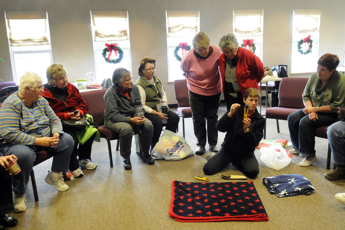 Erin Haugh shows a group of the Valley Assembly Quilters a tool that she uses to punch holes on the edge of a quilt in preparation for lacing or crocheting. The group meets in a donated room at the Valley Assembly of God, shares a common interest in quilting and provides quilts to Providence Sacred Heart Medical Center’s cancer unit. (J. Bart Rayniak)