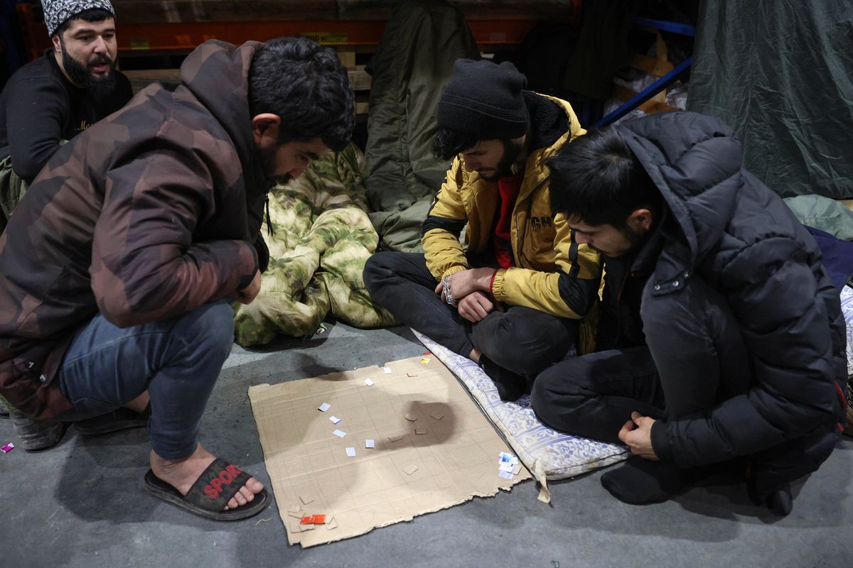 Migrants plays in the logistics center of the checkpoint "Bruzgi" at the Belarus-Poland border near Grodno, Belarus, Wednesday, Dec. 1, 2021. The West has accused Belarusian President Alexander Lukashenko of luring thousands of migrants to Belarus with the promise of help to get to Western Europe to use them as pawns to destabilize the 27-nation European Union in retaliation for its sanctions on his authoritarian government. Belarus denies engineering the crisis.  (Oksana Manchuk)