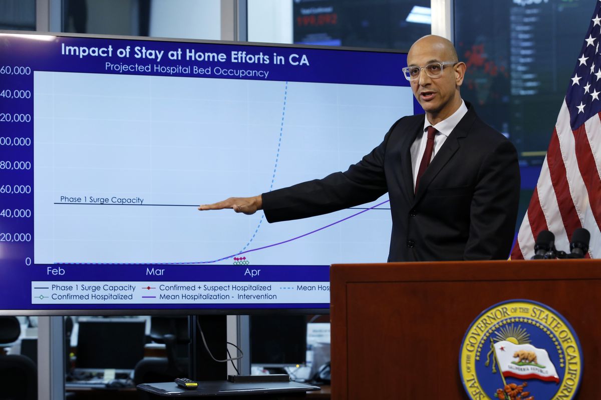 FILE - In this April 1, 2020, file photo Dr. Mark Ghaly, secretary of the California Health and Human Services, gestures to a chart showing the impact of the mandatory stay-at-home orders during a news conference ,at the Governor