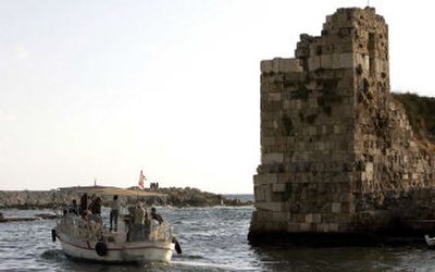
Tourists ride past an ancient fortress at the Phoenician port city of Byblos whose foundations are seen blackened by scum from an oil spill, in this picture taken on in August. 
 (Associated Press / The Spokesman-Review)