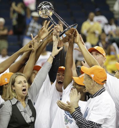 Lynx head coach Cheryl Reeve, left, joins her team in hoisting up the WNBA championship trophy after topping Atlanta 86-77. (Associated Press)