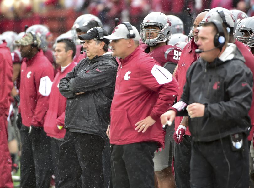 Washington State head coach Mike Leach, center, and his staff watch Saturday’s setback unfold during the second half at Martin Stadium.