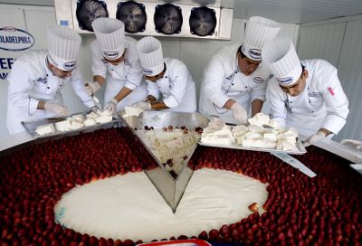 Chefs serve  the world’s largest cheesecake in Mexico City on Sunday.  (Associated Press / The Spokesman-Review)