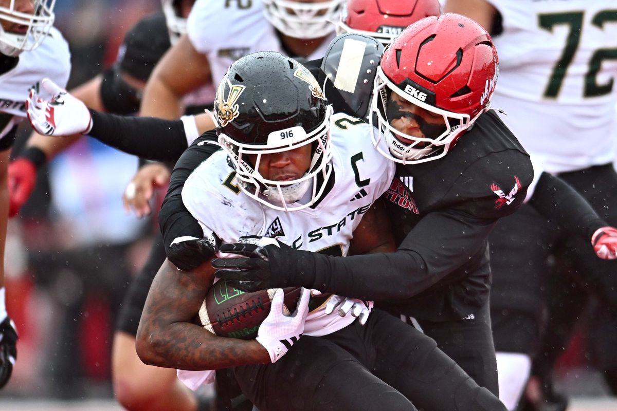 Sacramento State Hornets running back Rodney Hammond Jr. (2) is stopped for a loss by Eastern Washington Eagles defensive end Tylin Jackson (1) in the first half of a Big Sky football game on Saturday, Nov. 1, 2025, at Roos Filed in Cheney, WA.  (James Snook)