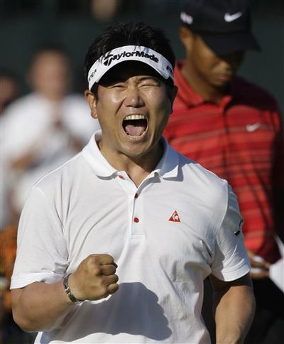 Y.E. Yang, of South Korea, celebrates after winning the 91st PGA Championship at the Hazeltine National Golf Club in Chaska, Minn., Sunday, Aug. 16, 2009. Behind his Tiger Woods. (AP Photo/Charlie Neibergall) (AP News)