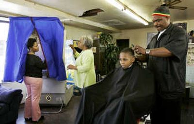 
Maurice Scott, 8, gets a haircut from Marcus Williams  as Rosa Fortt, left, asks a question of polling volunteer Eugenia Gary during the Pennsylvania primary Tuesday at Toni's Barber Shop in Philadelphia. Associated Press
 (Associated Press / The Spokesman-Review)