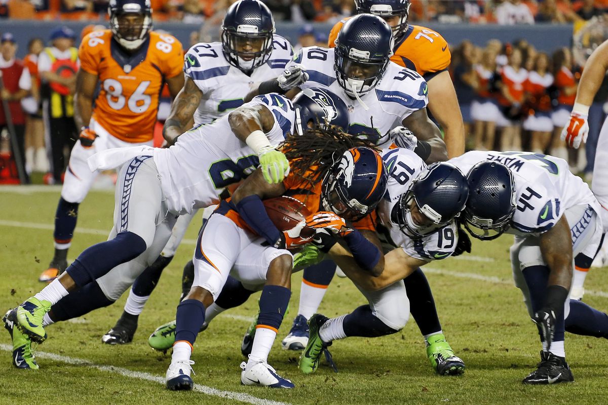 Denver Broncos’ Isaiah Burse, center, is brought down by a flock of Seahawks, including Ricardo Lockette, left, during the first half. (Associated Press)