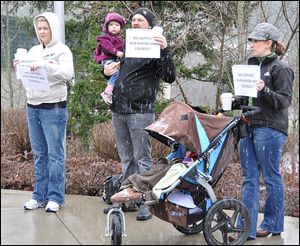 Jennifer Drake (left), with husband, Ben, and Sara Meyer are shown protesting the launch of the unsuccesful 2012 recall effort against then mayor Sandi Bloem and three council members. The two women later would be instrumental in stopping the effort that divided the city of Coeur d'Alene. (Coeur d'Alene Press file photo)