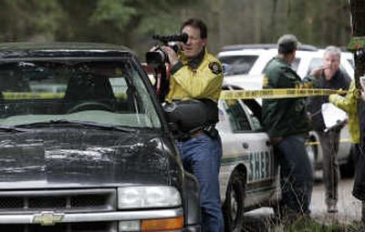 
A King County sheriff's deputy records a pickup truck at a crime scene where six people were found dead Wednesday. Associated Press
 (Associated Press / The Spokesman-Review)