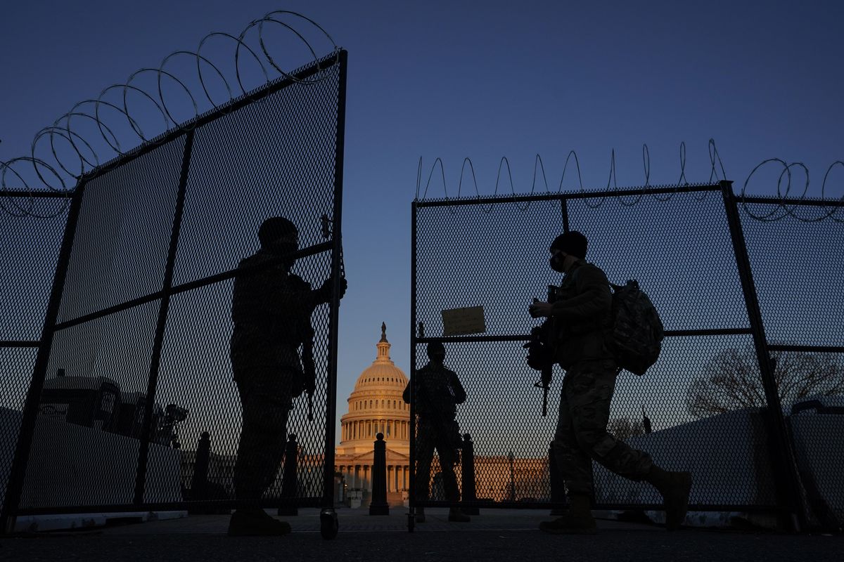 FILE - In this March 8, 2021, file photo, members of the National Guard open a gate in the razor wire topped perimeter fence around the Capitol at sunrise in Washington. Threats to members of Congress have more than doubled this year, according to the U.S. Capitol Police, and many members say they fear for their personal safety more than they did before the siege.  (Carolyn Kaster)