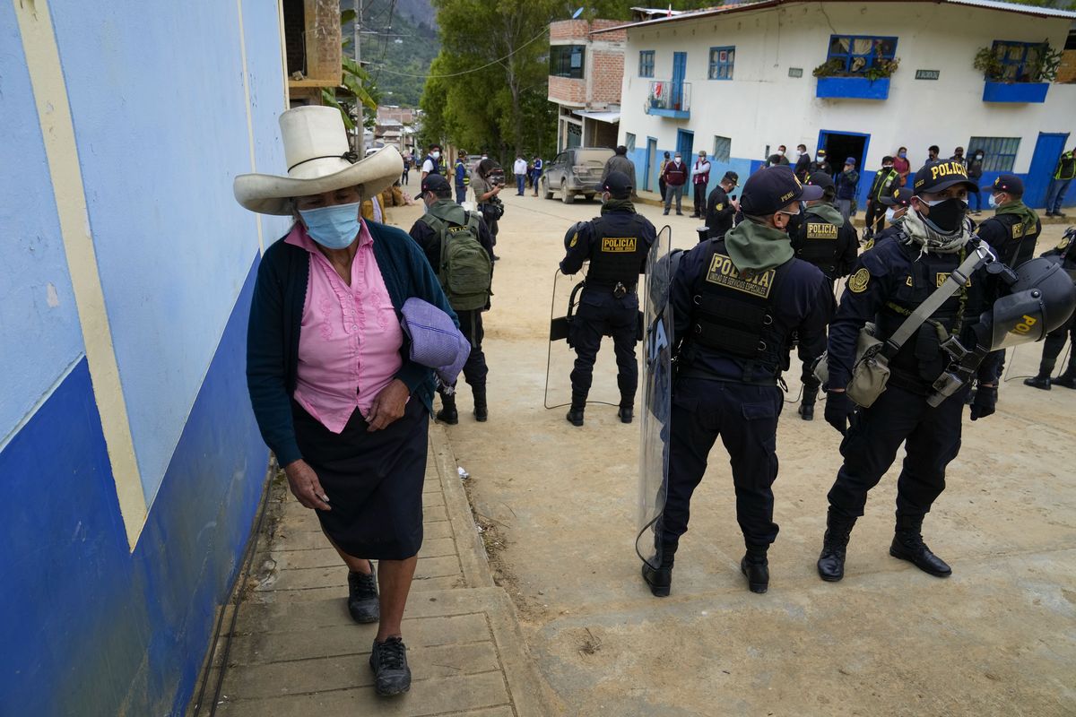 A voter arrives to a polling station guarded by police in Tacabamba, Peru, Sunday, June 6, 2021. Peruvians vote Sunday in a presidential run-off election to choose between Pedro Castillo, a political novice who until recently was a rural schoolteacher, and Keiko Fujimori, the daughter of jailed ex-President Alberto Fujimori.  (Martin Mejia)