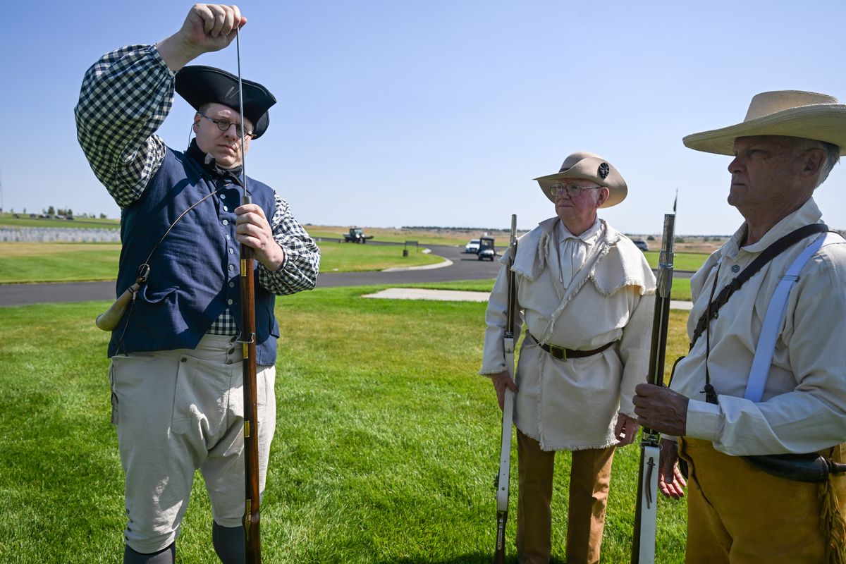 At the service to bury the long-unclaimed remains of Civil War veteran John Staples, rifle salute participant Tracey Prock, left, along with team members Dale Ryan and Stan Mills, carefully packs black pounder into his flintlock musket outside the Medical Lake veterans cemetery shelter where distant relatives of John and Martha Staples watched the tradition of military honors, including a gun salute with muskets, given for their distant relatives.  (Jesse Tinsley/THE SPOKESMAN-REVIEW)