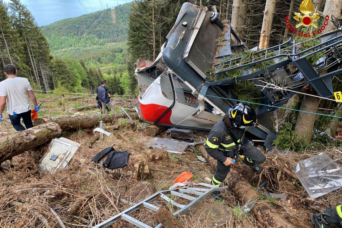 Rescuers work by the wreckage of a cable car after it collapsed near the summit of the Stresa-Mottarone line in the Piedmont region, northern Italy on Sunday.  (HONS)