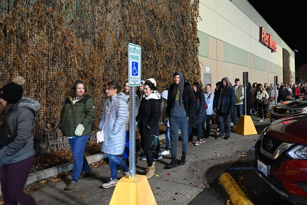 Shoppers stream toward the doors of the Fred Meyer store in Spokane Valley at the 5 a.m. opening on Black Friday. Hundreds were in line well before the early opening, some enticed by a gift card giveaway.  (Jesse Tinsley/The Spokesman-Review)