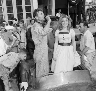 In this June 21, 1959 file photo, Texas driver Carroll Shelby enjoys a swig of champagne after combining with British veteran Roy Salvadori to win the 24-Hour Endurance Auto Classic at Le Mans, France. Dressing up the picture is Miss Sophie Destrade, of France, Miss Europe of 1959. Shelby, the legendary race driver and Shelby Cobra sports car designer, has died at age 89.   (Jacques Marqueton / AP Photo)