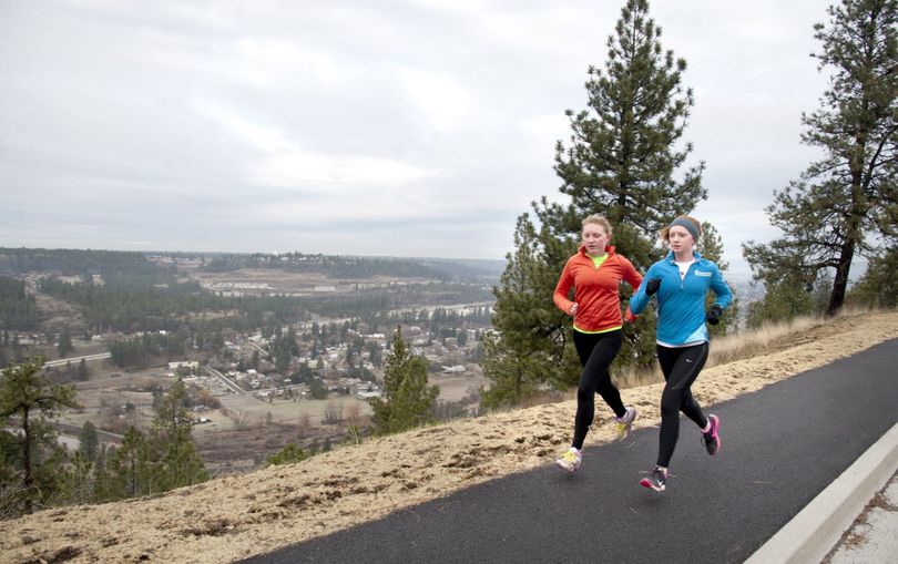 Sisters Katrin, left, and Maya Pardue, 19 and 17, respectively, run up High Drive in Spokane Tuesday, Dec. 23, 2014. Spokane was named 2014 Outstanding Runner Friendly Community of the Year by the Road Runners Club of America. (Jesse Tinsley)