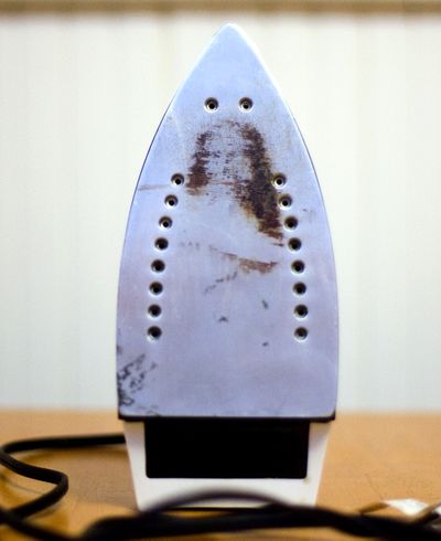 A woman in Methuen, Mass.,  sees an image of Jesus Christ in the  residue on the bottom of  her iron.  (Associated Press)