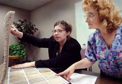 
Tesia Walsky, left, and Jacquelyn Parke look at carpet samples at the Community Frameworks office for Parke's new Spokane Valley condominium. 
 (Joe Barrentine / The Spokesman-Review)