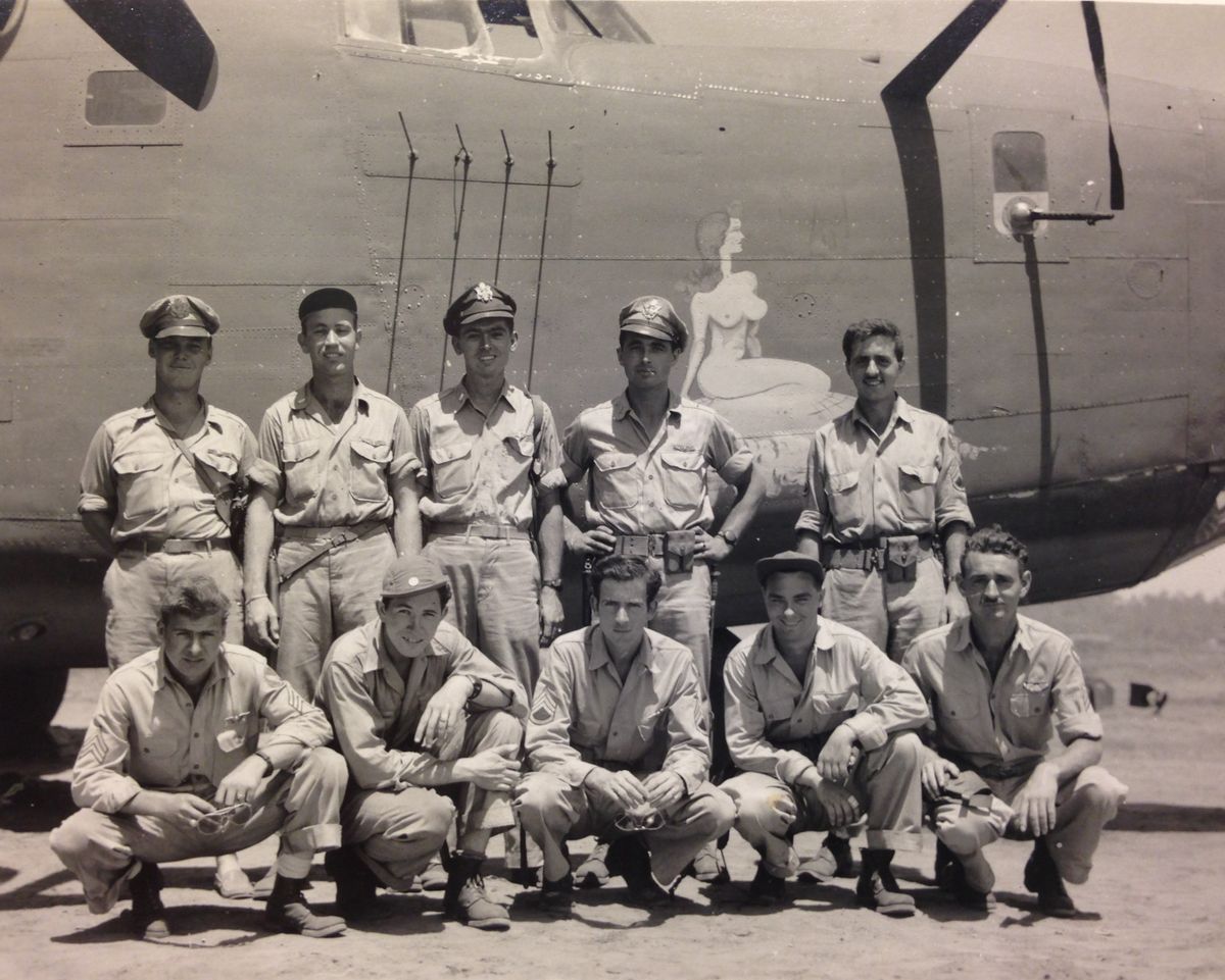 Crew photo for the Heaven Can Wait bomber in Papua New Guinea. Second Lt. Thomas V. Kelly Jr. is the middle figure in the back row, standing, with his .45 pistol in a shoulder holster. The ring recovered from the wreckage is visible on his left hand.  (Courtesy of Scott Althaus)