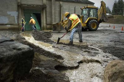 Spokane Water Department workers channel water out of a pump station at Ray Street and 23rd Court on Friday. Two men working in the basement were trapped when a pipe broke and flooded the building. Workers used the backhoe at right to knock open the doors to free the trapped workers.
(CHRISTOPHER ANDERSON / The Spokesman-Review)