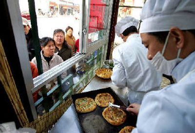 
Chefs prepare traditional savory snacks as customers line up outside to buy them at a newly opened restaurant in Beijing. When Beijing releases its annual economic census on Tuesday, outsiders expect it to make a greater effort to measure thriving service businesses, possibly revealing that China has been even more successful than reported over the past decade. 
 (Associated Press / The Spokesman-Review)