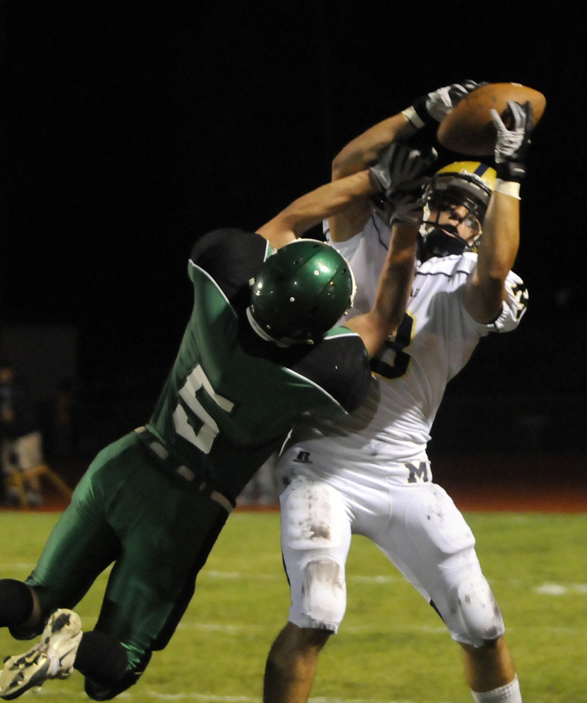 Mead’s Bo Tully pulls down a long pass while being guarded by East Valley’s Brad Dodd during the first halfof Friday’s game. (Jesse Tinsley / The Spokesman-Review)