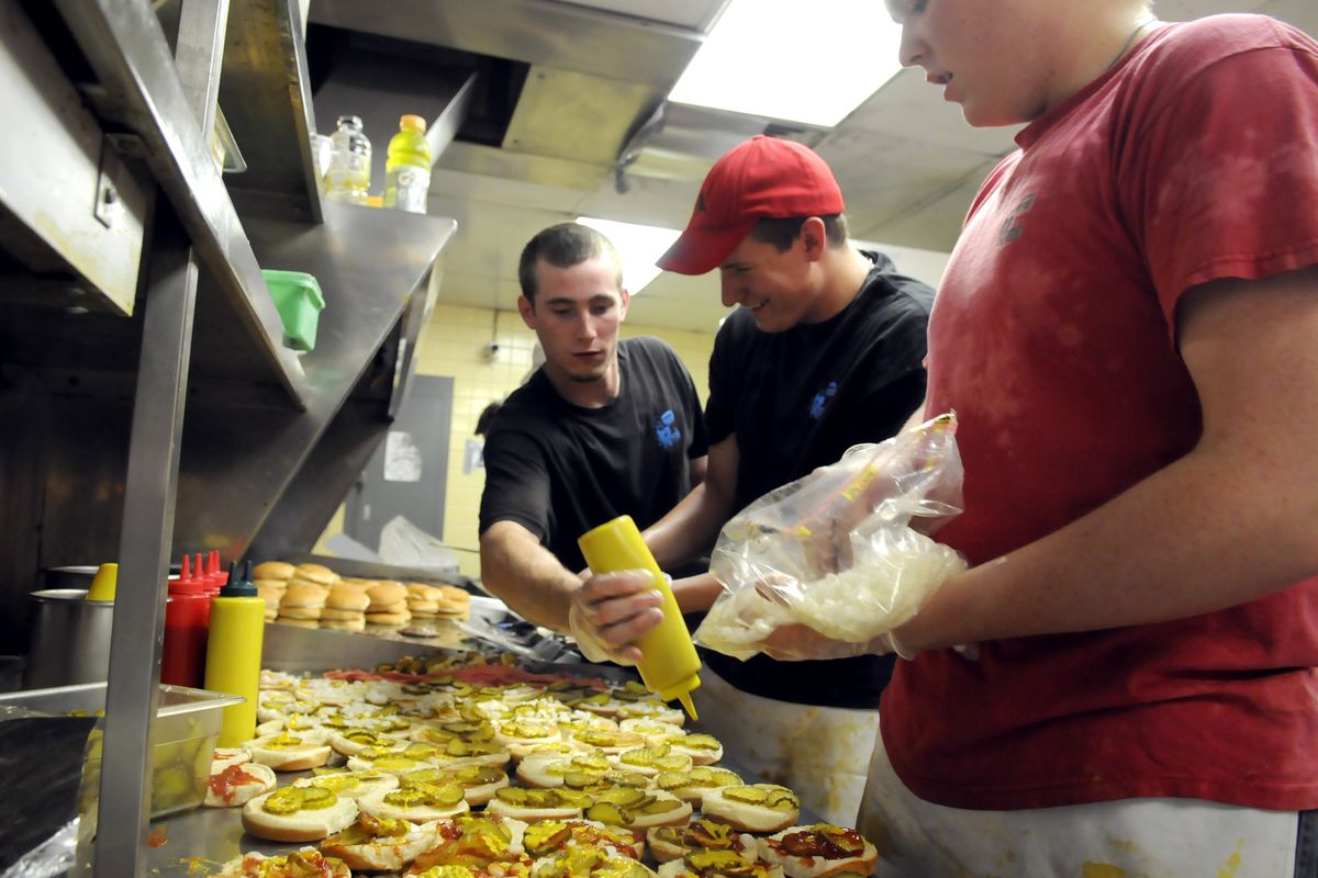 Cooks Jeremy Smith, Darrin Graham and Tyler Tveit  work frantically to churn out deluxe burgers at Ron’s Drive-in on Wednesday in Spokane Valley. Ron’s rolled back prices for its 52nd anniversary, charging only 19 cents for a deluxe burger or 57 cents for a combo meal.  (Jesse Tinsley)