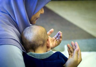 
Suriayani Raip listens during the Eid Al-Adha service with her 3-month-old son, Zacharia Hill, at CenterPlace in Spokane Valley on Tuesday morning. 
 (Holly Pickett / The Spokesman-Review)