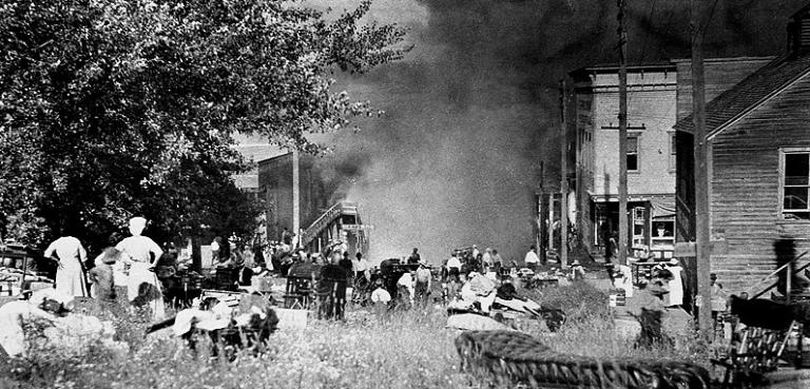 Stunned, on July 21, 1917, townspeople of Harrison, Idaho, watch the smoke billowing from an inferno that destroyed the town’s business district and half the residential area. This photo is from an article written by Estar Holmes about the 1917 fire: “The Town That Few Out of Fire: The Inferno on Lake Coeur d’Alene.” (Courtesy photo)