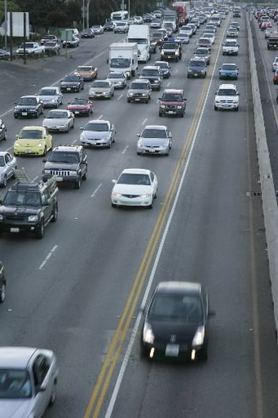 A Toyota Prius, front, zips along during rush hour in the carpool lane of the southbound 405 Freeway.