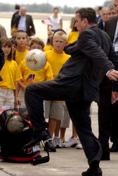 
German Chancellor Gerhard Schroeder demonstrates his soccer skills for Glyndale Elementary School children from Brunswick, Ga., after arriving at Hunter Army Airfield in Savannah, Ga., on Tuesday.
 (Associated Press / The Spokesman-Review)