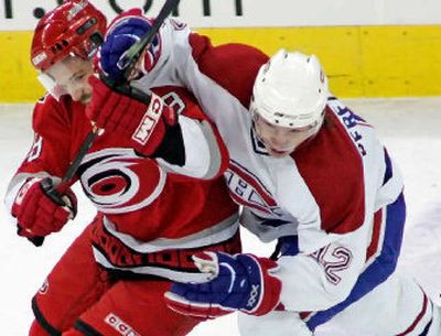 
Carolina's Mark Recchi, left, draws a hooking penalty from Montreal's Alexander Perezhogin in the second period.
 (Associated Press / The Spokesman-Review)