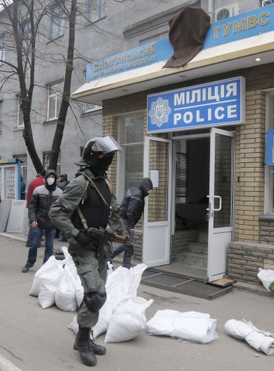 Armed pro-Russian activists occupy the police station in riot gear in the eastern Ukraine town of Slovyansk on Saturday. (Associated Press)