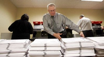 
Elections worker Glenn Armstrong moves ballots during counting for December's  recall election of Spokane Mayor James West. A proposed charter amendment would alter the recall process. 
 (FILE Associated Press / The Spokesman-Review)