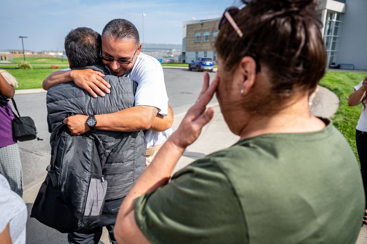Evaristo Salas, in glasses, is greeted by his father, Ruben Alvarado, after walking out of the Airway Heights Corrections Center in Spokane County a free man on Thursday as his stepmother, Maria Alvarado, wipes a tear.  (COLIN MULVANY/THE SPOKESMAN-REVIEW)