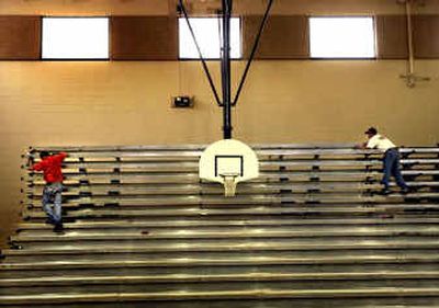
Workers put finishing touches on bleachers in the gym at Greenacres Middle School on Thursday. Renovations are expected to be done by the time school starts.
 (Brian Plonka / The Spokesman-Review)