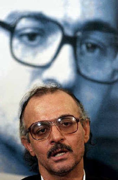 
Iranian history professor, Hashem Aghajari, speaks with the media in front of his picture at his home after being released on bail Saturday.
 (Associated Press / The Spokesman-Review)