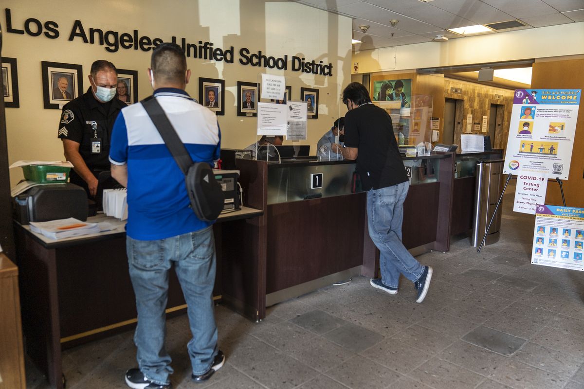Visitors wait in line to be screened by security before being allowed to enter the Los Angeles Unified School District administrative offices in Los Angeles Thursday Sept. 9, 2021. The Los Angeles board of education is expected to vote Thursday, on whether to require all students 12 and older to be fully vaccinated against the coronavirus to participate in on-campus instruction in the nation