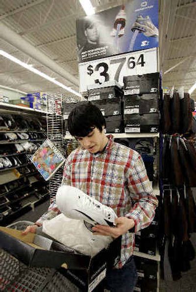 
Brian Anderson, 17, of Vancouver, Wash., shops for a pair of Starter Pro sneakers at a Wal-Mart store. 
 (Associated Press / The Spokesman-Review)