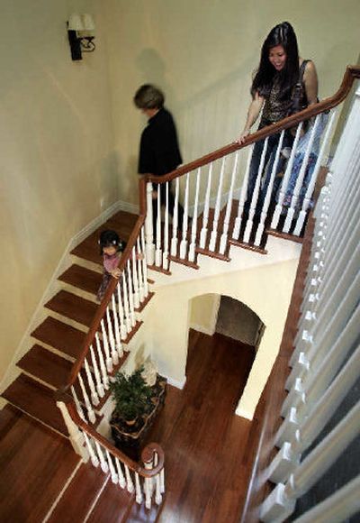 
Carol Uyeno, right, and daugther Taylor Yamashita, left, 4, and Leslie Zeisler, a Realtor with Midtown Realty, center, walk down the staircase of a new home Uyeno hopes to buy in Palo Alto, Calif. The home's asking price of $2.3 million was recently reduced. 
 (Associated Press / The Spokesman-Review)