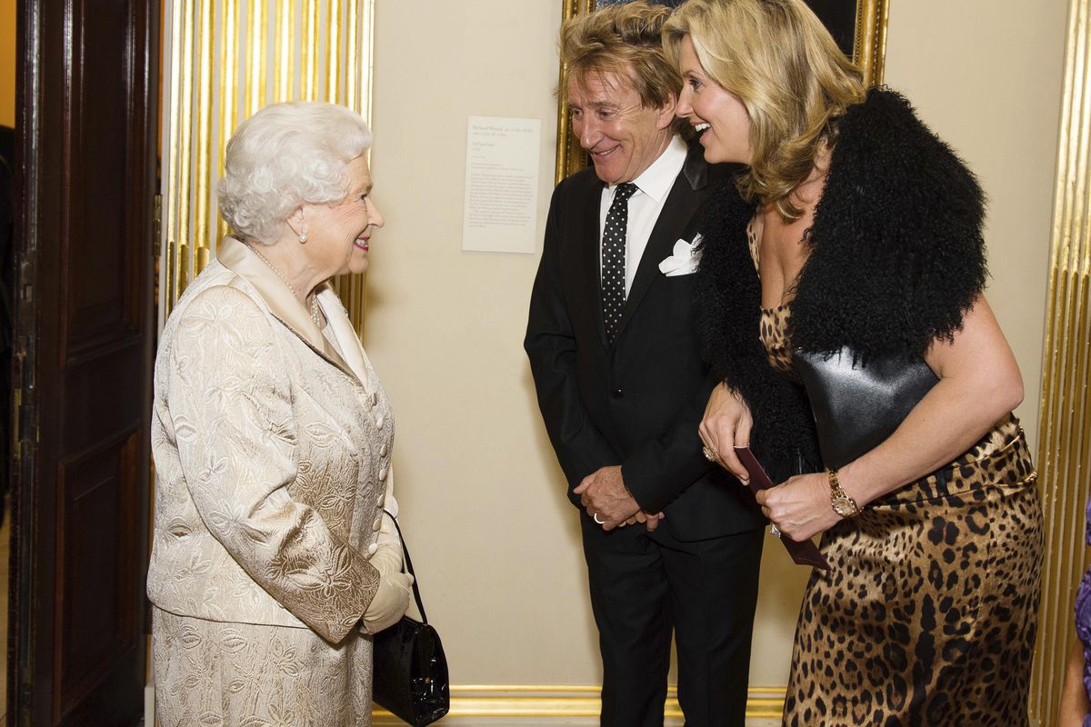 Britain’s Queen Elizabeth greets Sir Rod Stewart and wife Penny Lancaster after he was awarded a knighthood in recognition of his services to music and charity earlier in the day, at a reception and awards ceremony at Royal Academy of Arts, London, Tuesday, Oct. 11, 2016. (Jeff Spicer / Associated Press)