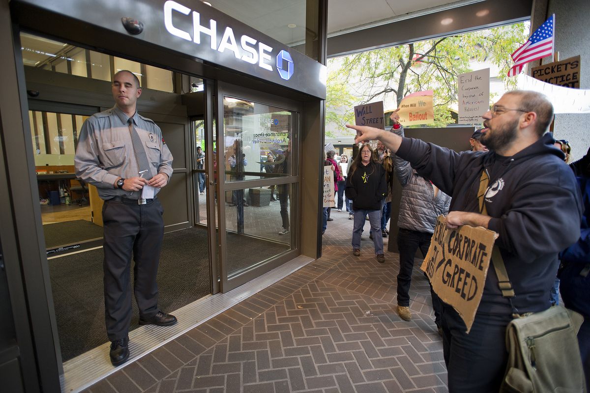 Occupy Spokane protester Robert Horton chants, “We are the 99 percent” to a security guard in front of Chase Bank on Friday. (Colin Mulvany)