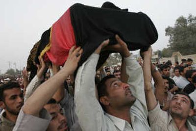 
Family members and mourners raise the coffin of Riyadh al Nouri during the funeral march in the Shiite holy city of Najaf, 100 miles south of Baghdad,  on Friday. Associated Press
 (Associated Press / The Spokesman-Review)