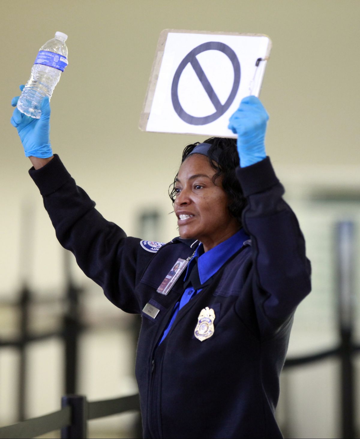 A TSA employee advises travelers that liquids are not allowed through the gate at at the Los Angeles International Airport Wednesday, Oct. 10, 2012.  In an age when travelers have to toss bottled water at airport security checkpoints, what may be most striking about the arrest of a passenger from Japan wearing a bulletproof vest and flying with checked luggage loaded with a cache of weapons, shackles and body bags is that most of it wasn