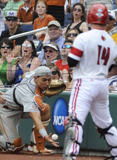 Texas catcher Tres Barrera reaches for but does not catch a foul ball hit by Louisville's Kyle Gibson (14) in the fifth inning. (Associated Press)