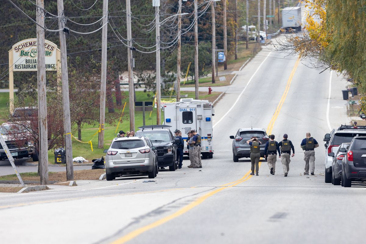 Above: Members of the FBI Evidence Response Team gather at the site of a mass shooting at Schemengees Bar and Grille on Thursday in Lewiston, Maine.  (Scott Eisen)