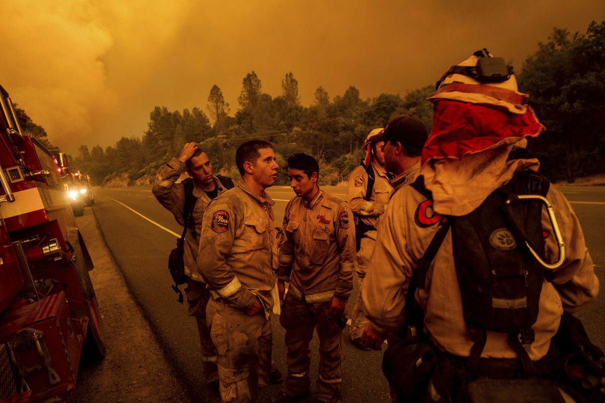 Firefighters discuss plans while battling the Carr Fire in Shasta, Calif., on Thursday, July 26, 2018. (Noah Berger / Associated Press)