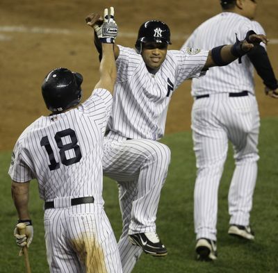 Robinson Cano celebrates with Johnny Damon (18) after scoring in the eighth inning on a throwing error. (Associated Press / The Spokesman-Review)