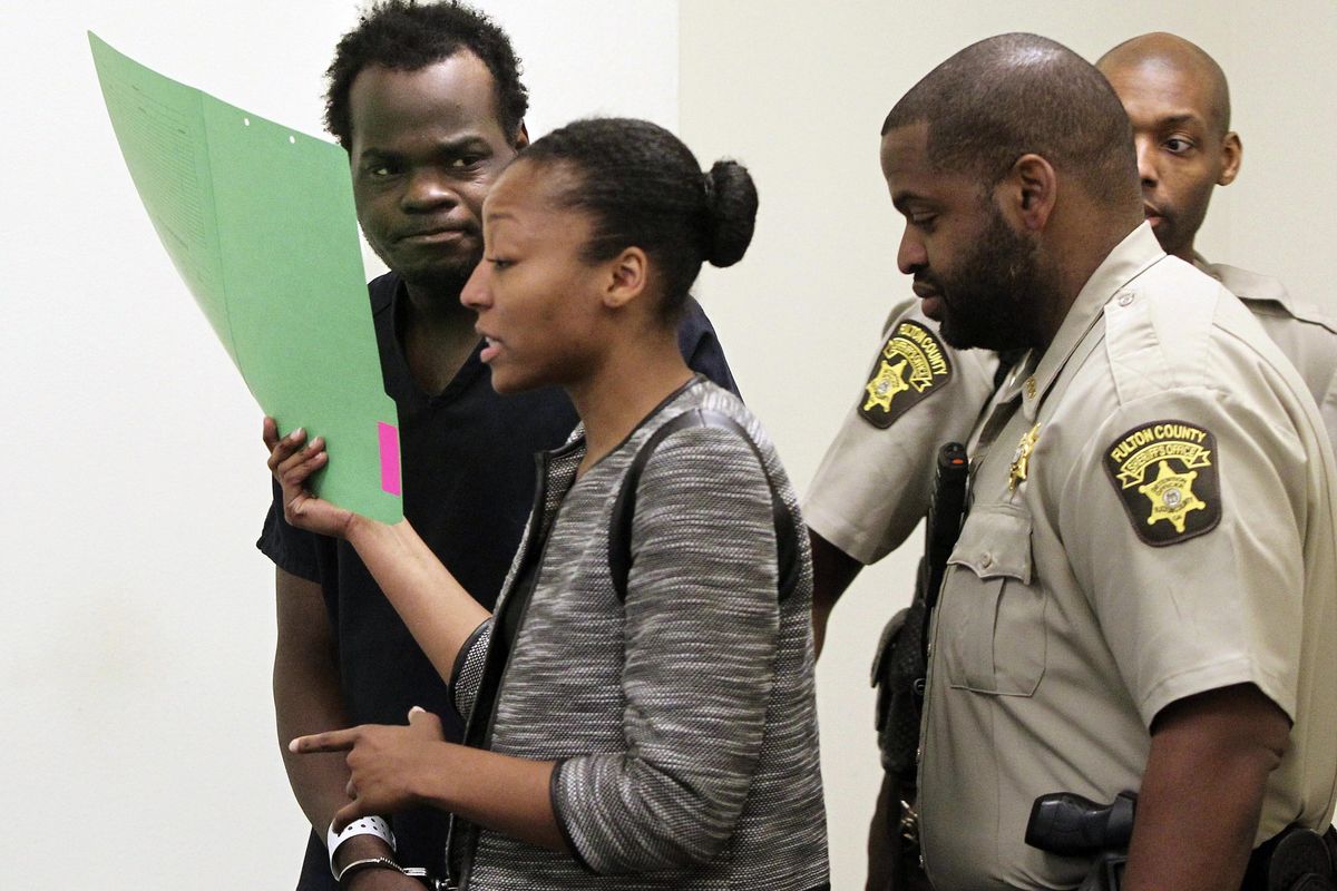 Basil Eleby is escorted by his public defender and two Fulton County Sheriff's office officers into the court room at the Fulton County Jail in Atlanta on Saturday. Eleby, accused of starting a raging fire that collapsed a portion of Interstate 85 a few miles north of downtown Atlanta was charged with arson. The first-degree arson charge was added to a first-degree criminal damage to property charge Eleby already faced in connection with the fire Thursday evening that caused a heavily traveled overpass to disintegrate. Total bond was set at $200,000. (Henry P. Taylor / Associated Press)